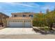 Two-story home featuring a three-car garage, desert landscaping and tile roof at 6251 Tuckaway Cove Ave, Las Vegas, NV 89139