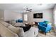 Cozy living room with a large sectional, blue accent chairs, and a ceiling fan at 6251 Tuckaway Cove Ave, Las Vegas, NV 89139