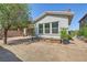 Backyard featuring mature tree, garden boxes, gravel, and privacy wall at 632 Cadence Vista Dr, Henderson, NV 89011