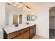 Bathroom featuring double sinks with dark hardware, tile floor, and a large mirror at 632 Cadence Vista Dr, Henderson, NV 89011