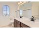 Bright bathroom featuring double sinks, framed mirror, and arch-topped window offering natural light at 632 Cadence Vista Dr, Henderson, NV 89011