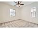 Neutral bedroom with a ceiling fan, carpet, and natural light from the two windows at 632 Cadence Vista Dr, Henderson, NV 89011