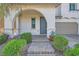 Inviting front porch with a gray front door, stone pavers, and lush green bushes at 632 Cadence Vista Dr, Henderson, NV 89011