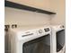 Laundry room featuring a Maytag washer and dryer with overhead shelving at 632 Cadence Vista Dr, Henderson, NV 89011