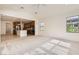 Open living room featuring plush carpet and seamless flow to kitchen with stainless appliances at 632 Cadence Vista Dr, Henderson, NV 89011