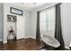 Comfortable bedroom with natural light, wood floors, and a cozy chair at 6409 Dundock Ave, Las Vegas, NV 89122