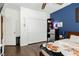 Cozy bedroom featuring wood floors, a ceiling fan, and a blue accent wall at 6409 Dundock Ave, Las Vegas, NV 89122
