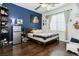 Cozy bedroom with wood floors, a blue accent wall, and window with blinds at 6409 Dundock Ave, Las Vegas, NV 89122