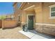 Inviting front entrance with a green door, decorative wreath, and charming stone accents and desert landscaping at 6409 Dundock Ave, Las Vegas, NV 89122