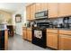 This kitchen has stainless steel appliances, wooden cabinets, and a mosaic backsplash at 6409 Dundock Ave, Las Vegas, NV 89122