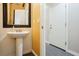 Well-lit powder room with a pedestal sink, framed mirror, and tile flooring at 6409 Dundock Ave, Las Vegas, NV 89122
