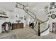 Spacious foyer with winding staircase, elegant decor, wood-look floors, and ample natural light at 7211 Heggie Ave, Las Vegas, NV 89131