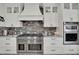 Elegant kitchen with white cabinets, stainless steel appliances, and stone backsplash at 7211 Heggie Ave, Las Vegas, NV 89131