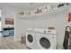 Bright laundry room with modern washer and dryer, shelving, and ample storage space at 7211 Heggie Ave, Las Vegas, NV 89131