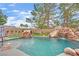 Backyard pool with rock waterfall, slide, and lounging area, creating a private retreat for relaxation at 7211 Heggie Ave, Las Vegas, NV 89131