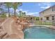 Backyard paradise with a pool, waterfall, slide, and gazebo offering a private and relaxing retreat at 7211 Heggie Ave, Las Vegas, NV 89131