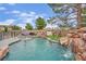 A pristine pool with a rock waterfall and a water slide enhances this backyard's appeal, great for summer fun at 7211 Heggie Ave, Las Vegas, NV 89131