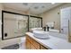 Bathroom featuring sleek vanity, modern sink, soaking tub with glass door, and neutral color palette at 7217 Mission Hills Dr, Las Vegas, NV 89113