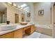 Bright bathroom featuring dual sinks, natural light, tub, and contemporary fixtures at 7217 Mission Hills Dr, Las Vegas, NV 89113
