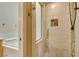 Stylish walk-in shower with a tiled surround and built-in niche, next to a soaking tub at 7217 Mission Hills Dr, Las Vegas, NV 89113