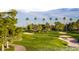 Scenic golf course with lush green grass, sand traps, and tall palm trees on a sunny day at 7217 Mission Hills Dr, Las Vegas, NV 89113