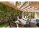 Inviting covered patio area with wooden table, chairs, and lush greenery for outdoor relaxation and dining at 7217 Mission Hills Dr, Las Vegas, NV 89113