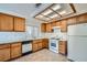Functional kitchen with wood cabinets, white appliances, and ample counter space at 725 Weatherstone Dr, Las Vegas, NV 89110