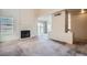 Spacious living room with a fireplace, large windows, and neutral-toned carpet at 725 Weatherstone Dr, Las Vegas, NV 89110