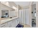 Bright bathroom with dual sinks, granite countertops, and a shower with curtain at 7910 Pearly Ct, North Las Vegas, NV 89084