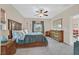 Spacious carpeted bedroom with a ceiling fan, a large bed, and warm natural light at 7910 Pearly Ct, North Las Vegas, NV 89084