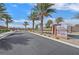 Gated community entrance with well-manicured landscaping, mature palm trees, and signage, creating a grand arrival experience at 7910 Pearly Ct, North Las Vegas, NV 89084