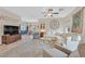 Bright living room with neutral tones, comfortable seating, and an open view to the dining area at 7910 Pearly Ct, North Las Vegas, NV 89084