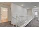 Hallway with carpet floors, white walls, access to rooms, and stairs to lower level at 10220 Adobe Mountain St, Las Vegas, NV 89178
