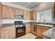 Cozy kitchen featuring granite countertops, stainless steel appliances, and light wood cabinetry at 10220 Adobe Mountain St, Las Vegas, NV 89178