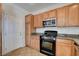 Well-lit kitchen with granite countertops, modern stainless steel microwave, and light wood cabinets at 10220 Adobe Mountain St, Las Vegas, NV 89178