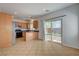 Eat-in kitchen with tile flooring, wood cabinets, and a sliding glass door to the backyard at 10220 Adobe Mountain St, Las Vegas, NV 89178