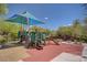 Community playground featuring slides, climbing structures, and picnic tables under a blue shade at 10220 Adobe Mountain St, Las Vegas, NV 89178