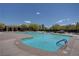 Large community pool with blue water, surrounded by lounge chairs and landscaping at 10220 Adobe Mountain St, Las Vegas, NV 89178