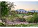 Landscaped backyard view includes the golf course, distant houses and mountains against the sunset at 10562 Cerotto Ln, Las Vegas, NV 89135