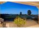 Backyard view with well-kept green space, desert plants, and a built-in outdoor grill at 10562 Cerotto Ln, Las Vegas, NV 89135