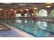 Bright indoor pool with lane dividers, large arched windows, and comfortable seating areas at 10562 Cerotto Ln, Las Vegas, NV 89135