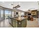 Bright kitchen featuring a large island, and views to the living room and golf course through sliding doors at 10562 Cerotto Ln, Las Vegas, NV 89135