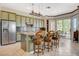 Kitchen with stainless steel appliances, a center island with barstool seating, and an adjacent dining area at 10562 Cerotto Ln, Las Vegas, NV 89135