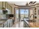Well-equipped kitchen featuring stone countertops, an island, and a view of the outdoors at 10562 Cerotto Ln, Las Vegas, NV 89135