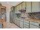 Modern kitchen with stainless steel appliances, granite countertops, and tile backsplash at 10562 Cerotto Ln, Las Vegas, NV 89135