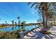 Scenic view of the pond featuring palm trees, lush greenery, and a relaxing seating area at 10562 Cerotto Ln, Las Vegas, NV 89135