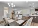 Open-concept dining room with a modern table and chairs adjacent to a kitchen with an island at 1114 Junipine Ave, North Las Vegas, NV 89081