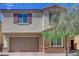 Charming two-story home with a two-car garage, stone accents, and colorful, desert landscaping at 1114 Junipine Ave, North Las Vegas, NV 89081