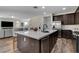 Open-concept kitchen with a central island and stainless steel appliances, flowing into the living area at 1114 Junipine Ave, North Las Vegas, NV 89081