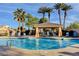 Community pool with tall palm trees, a covered seating area, and ample lounge chairs at 130 Twin Towers Ave, Las Vegas, NV 89123